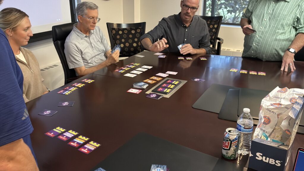 Players comparing Defense cards during a corporate Hack Attack: Defense session
